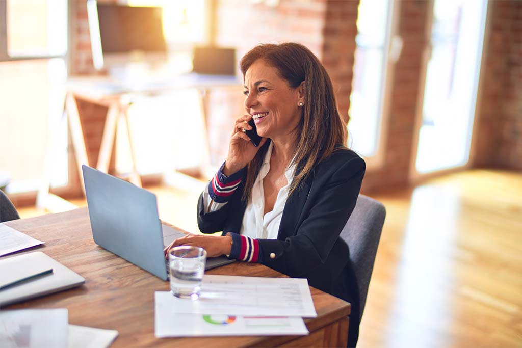 A woman on the phone at her desk